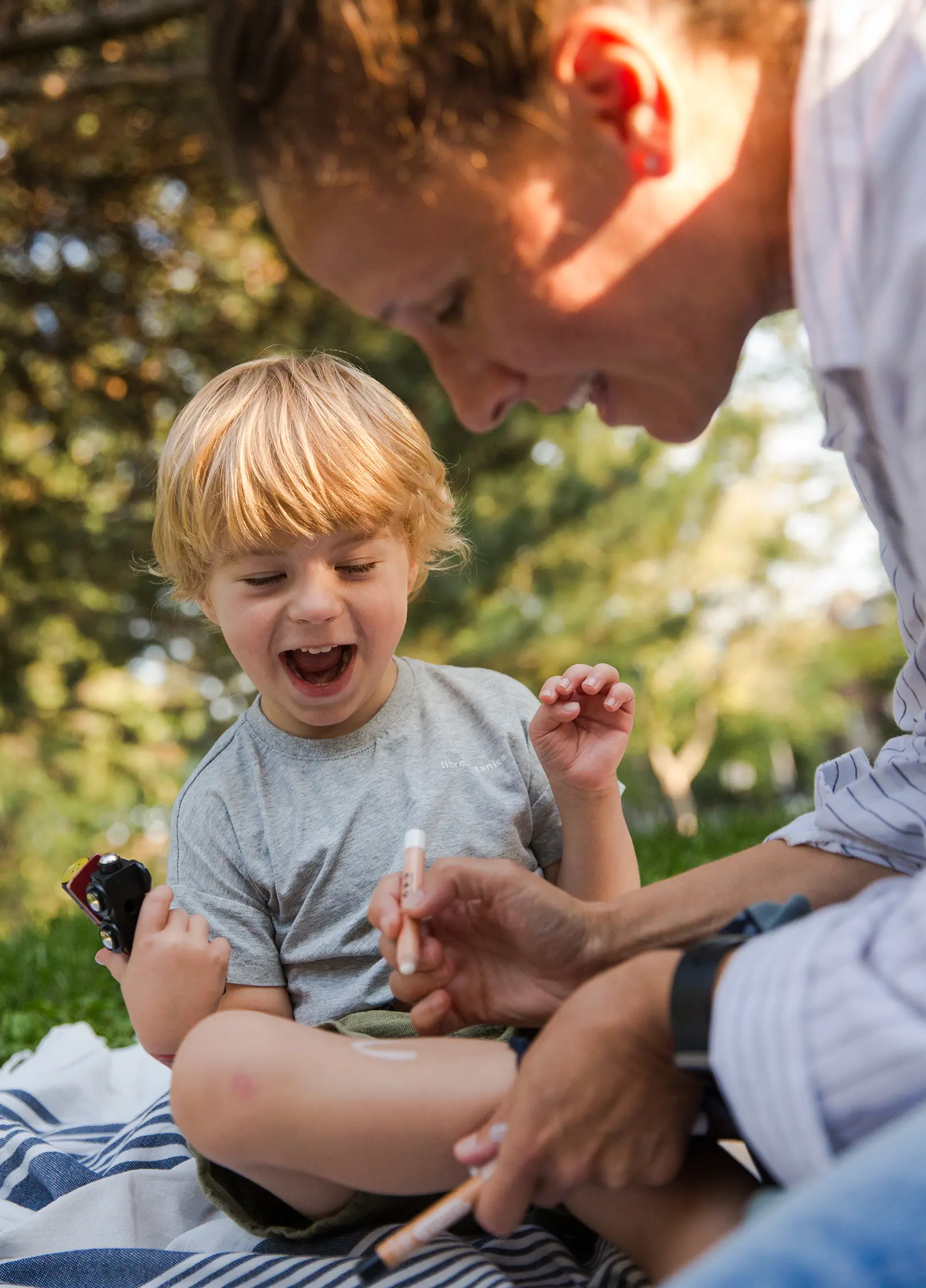 enfant et maman jouant avec un crayon de maquillage bio