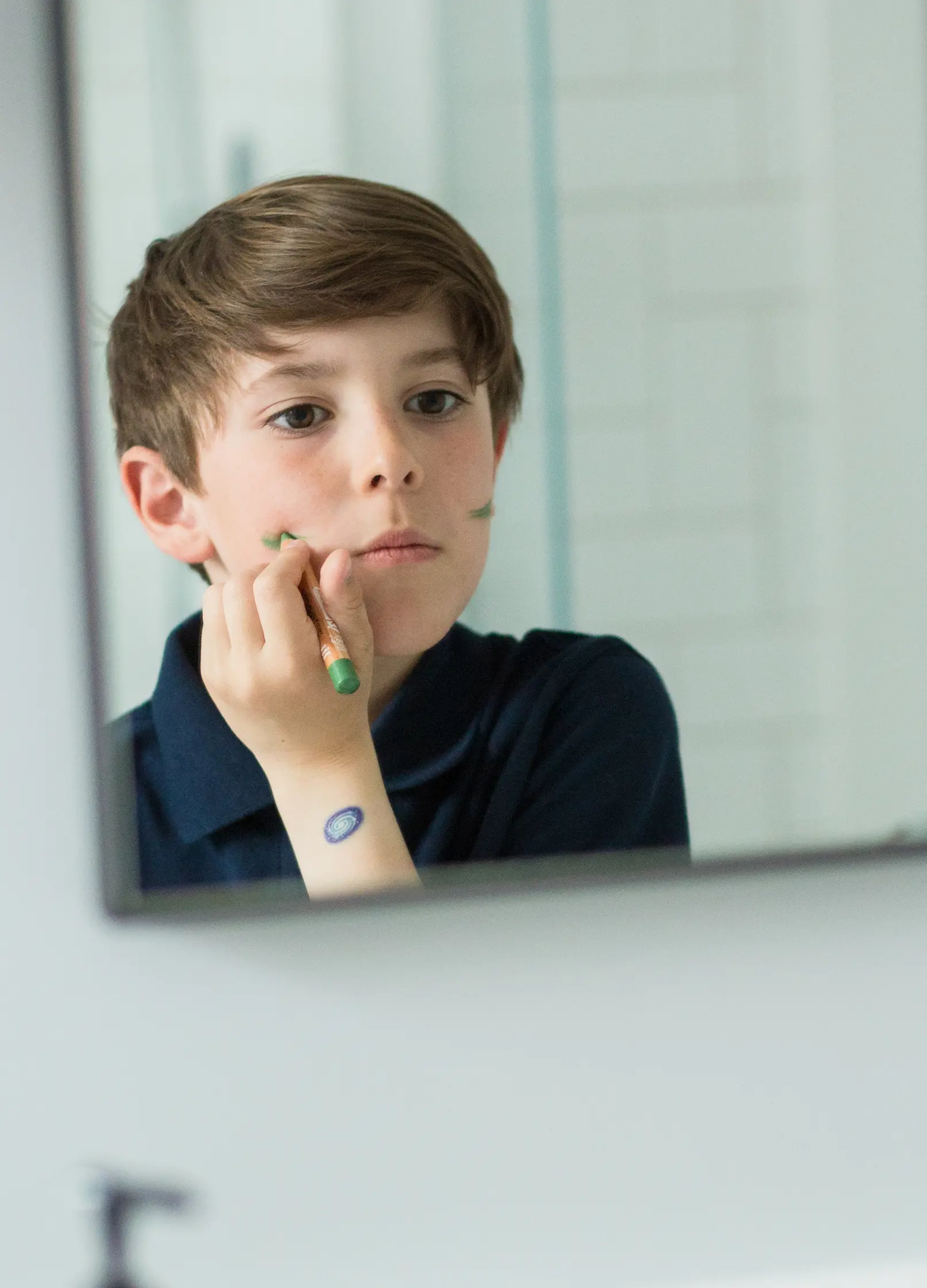 enfant utilisant un crayon de maquillage bio vert