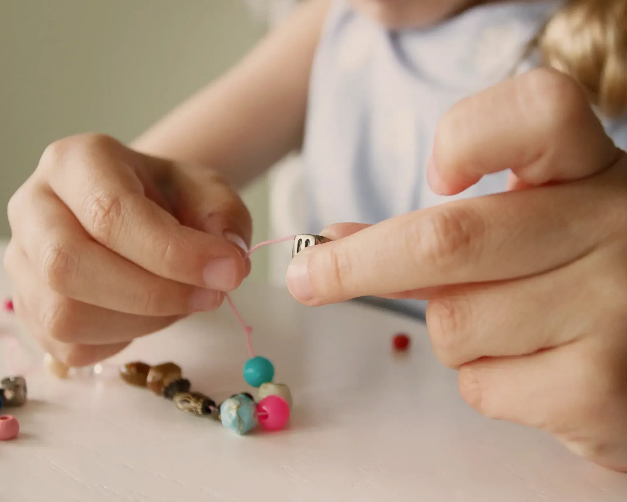 Kinder beim Basteln von Perlenketten