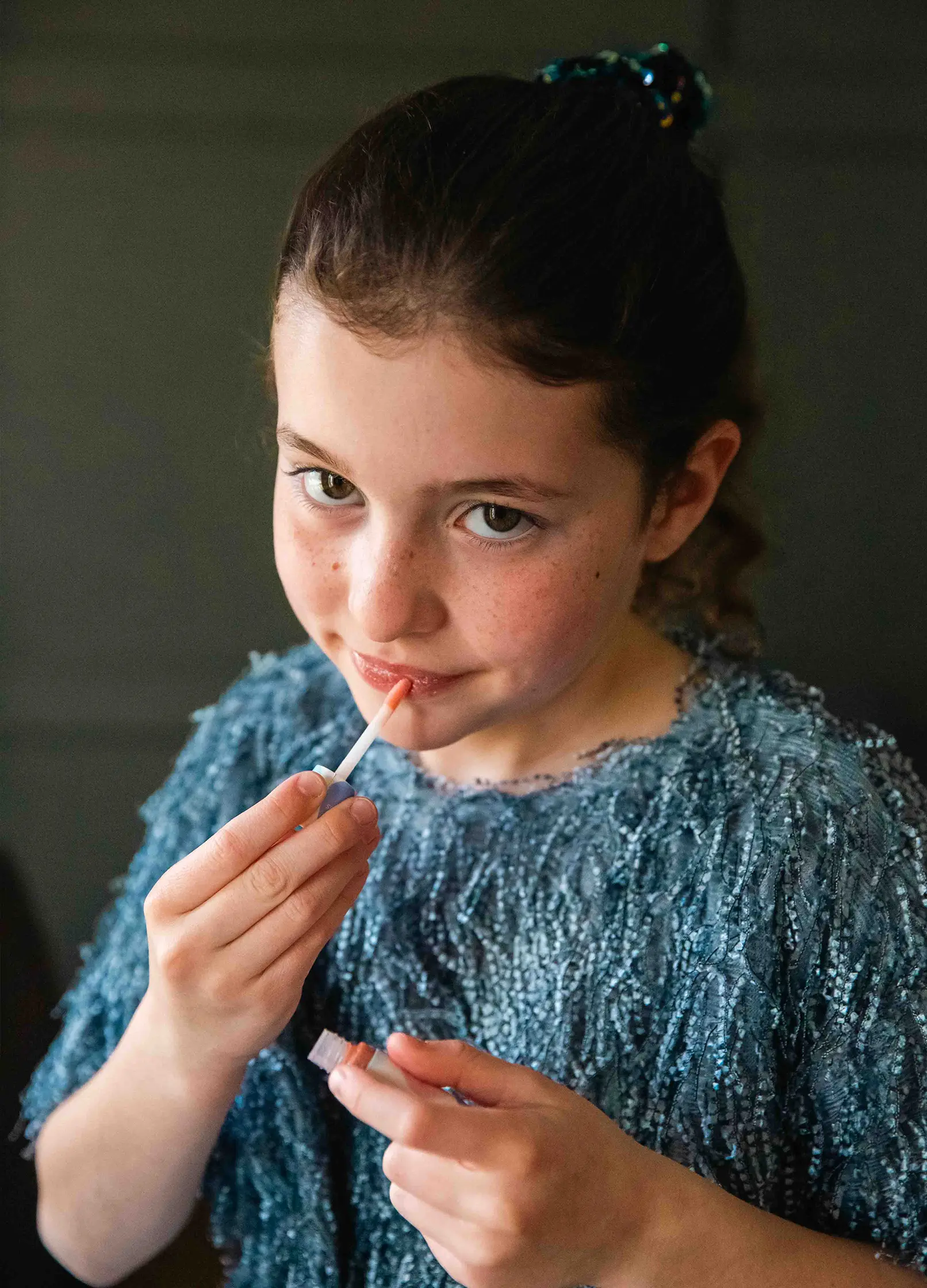 fille appliquant du gloss sur ses lèvres