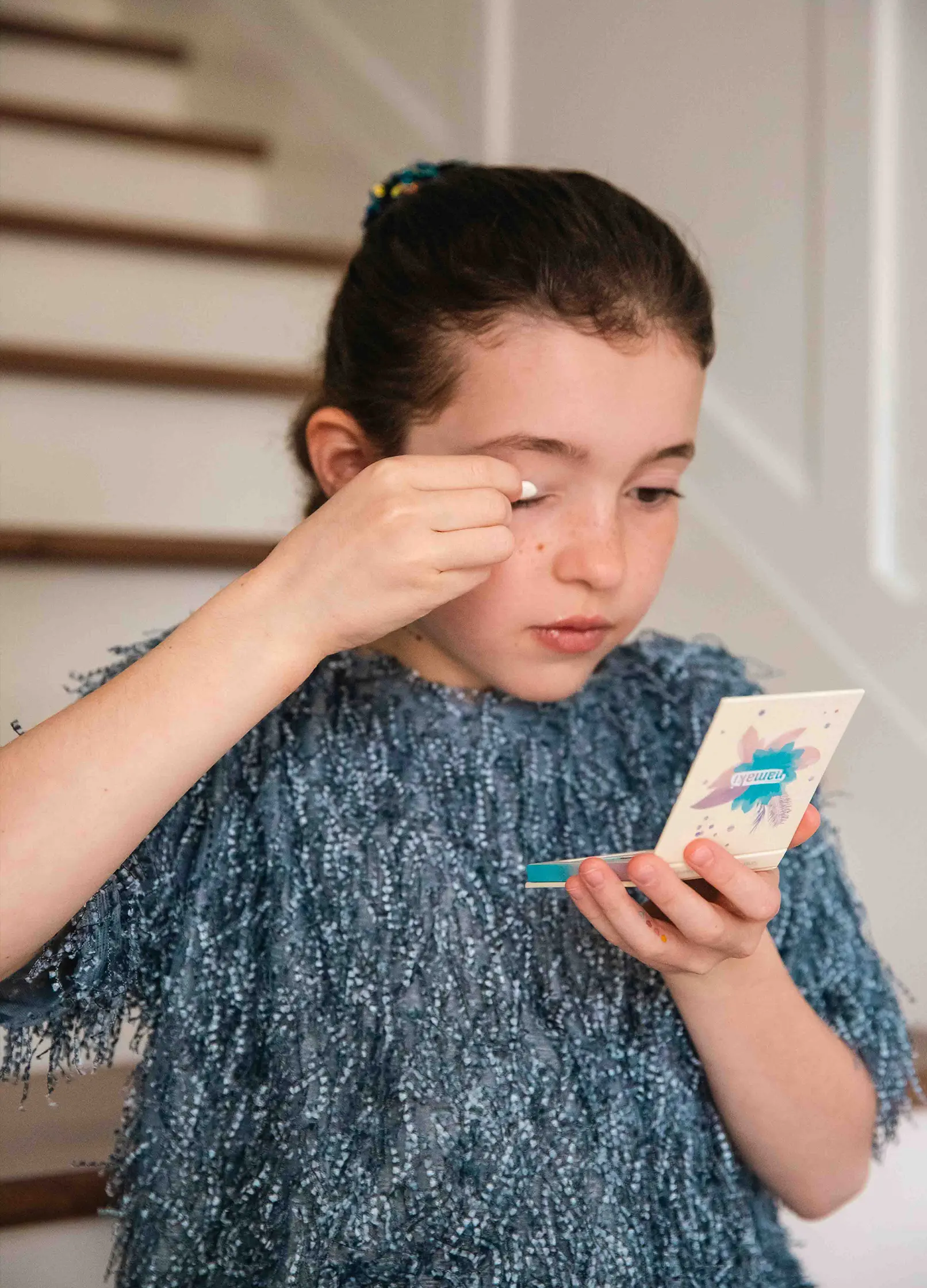 fille appliquant du fards sur ses paupières