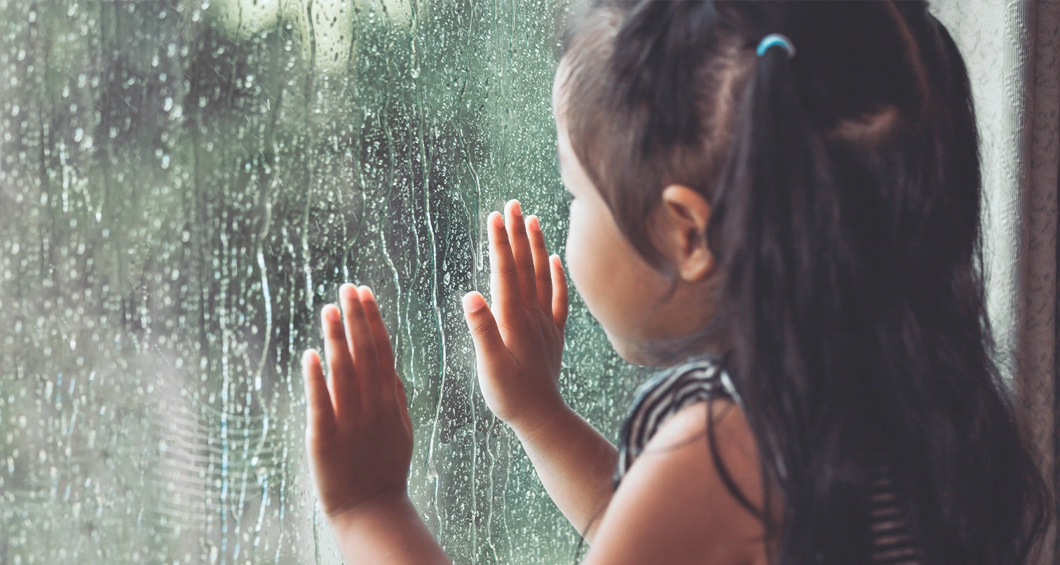 petite fille regardant la pluie
