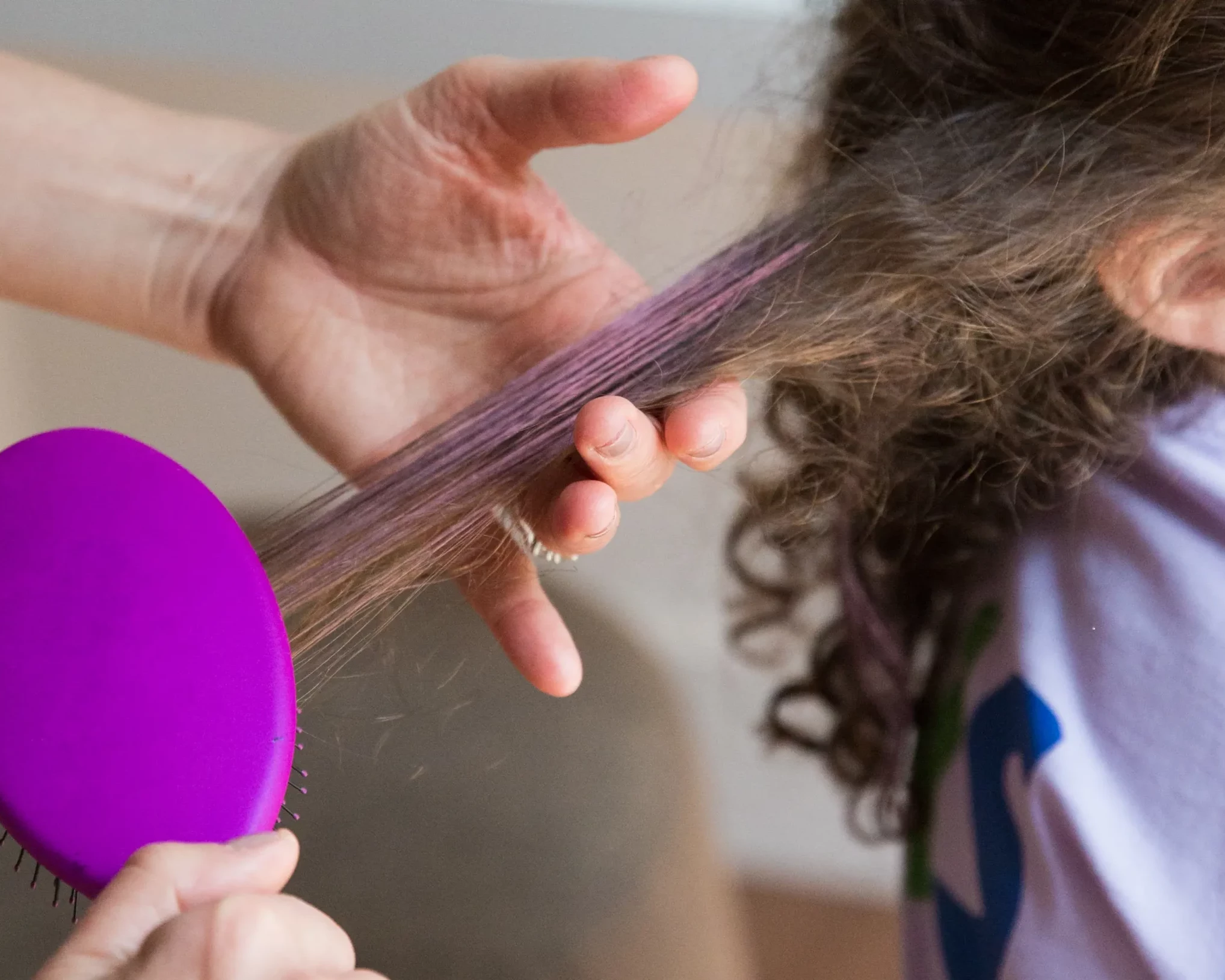 Haare mit rosa Mascara beim Bürsten